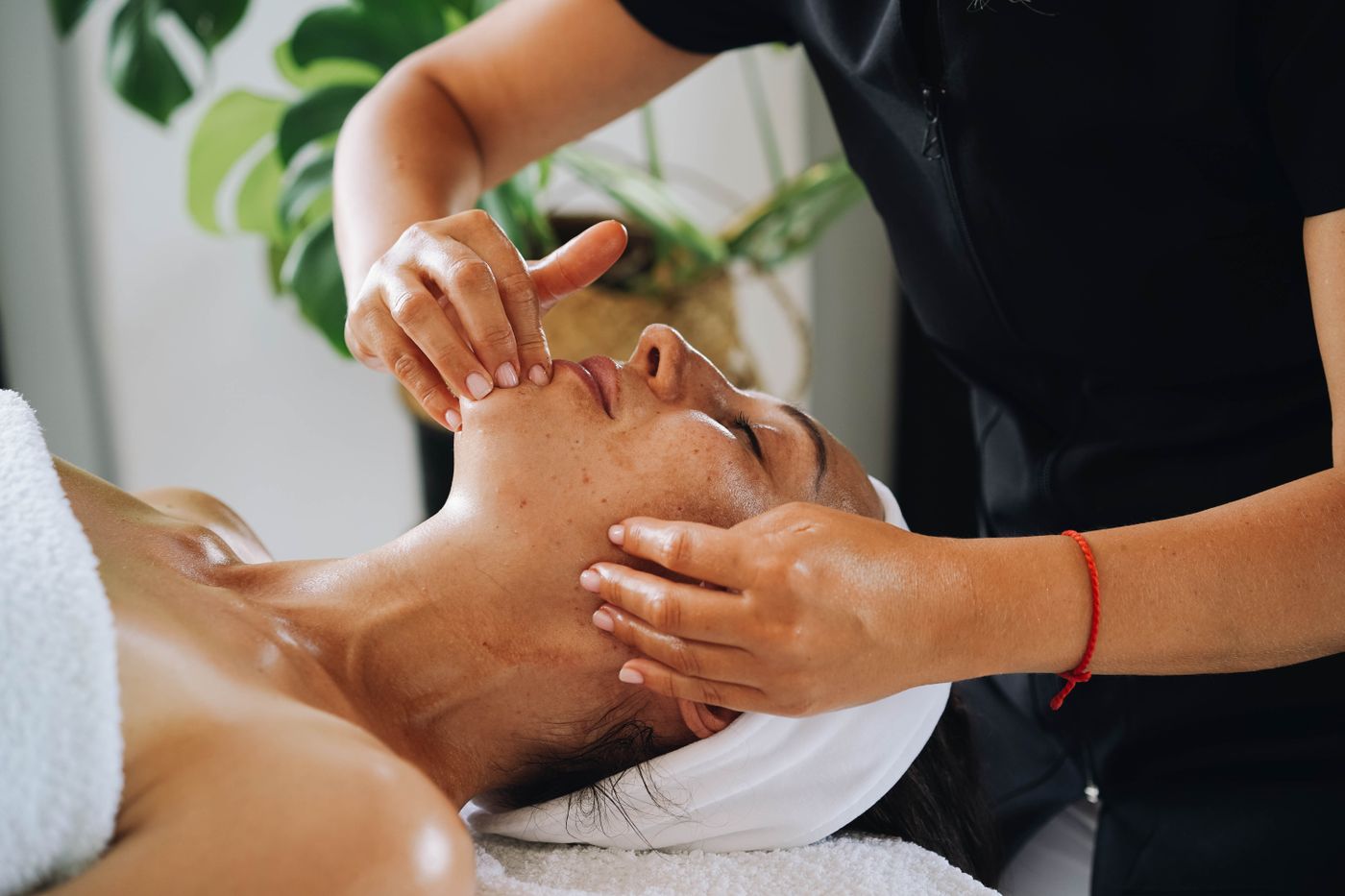 Gentle face and ear area massage in a spa treatment room in Dubai