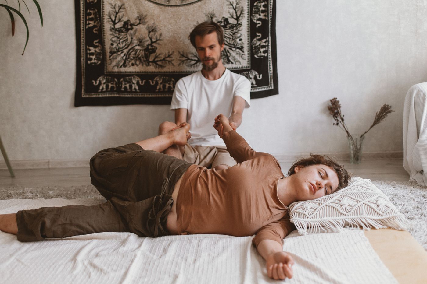 Therapist stretching a guest's arm during a Thai massage in Dubai